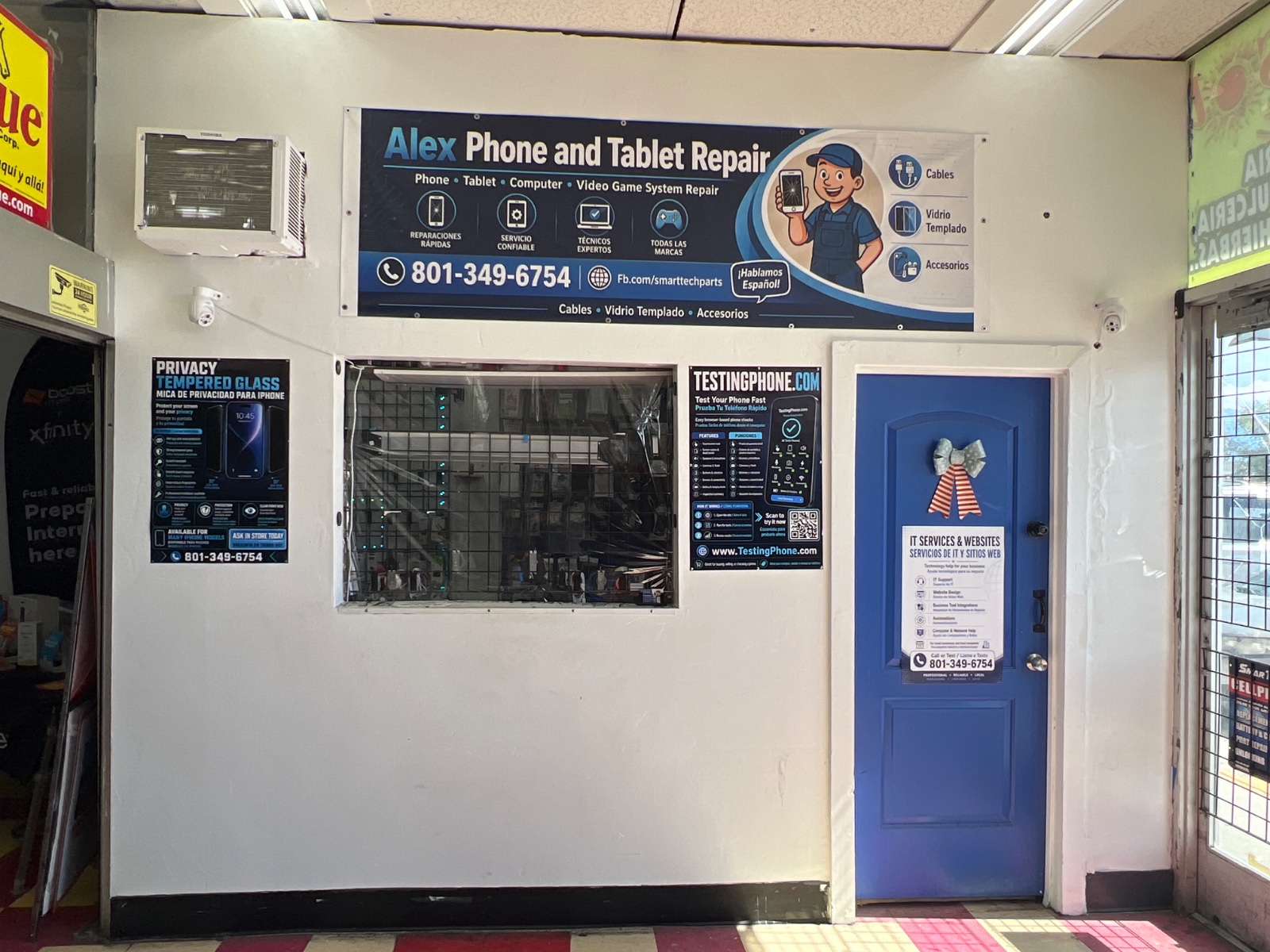 Service window and blue door inside Alex Smart Tech, under the phone and tablet repair banner.